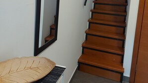 Eine Treppe mit Holzbodenstufen und schwarzen Geländern, die zu einer oberen Etage führt.