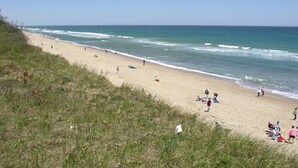 A beach with people walking and relaxing. - New Eastham Oceanside Guest Suite with Pool and Hot Tub (Eastham)