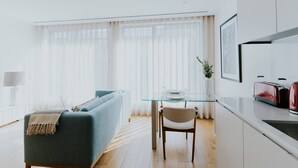 Un salon moderne avec un canapé, une table en verre et un fauteuil.