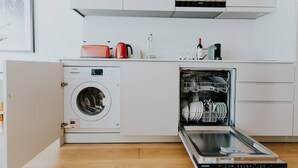 Une cuisine moderne équipée d’un lave-linge, d’un lave-vaisselle et d’un four à micro-ondes intégrés.
