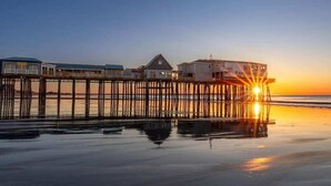 A pier extending into calm waters with buildings on it, likely a hotel or resort.