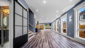 Un couloir doté d’un plancher en bois, d’une douche en verre et d’une cheminée.