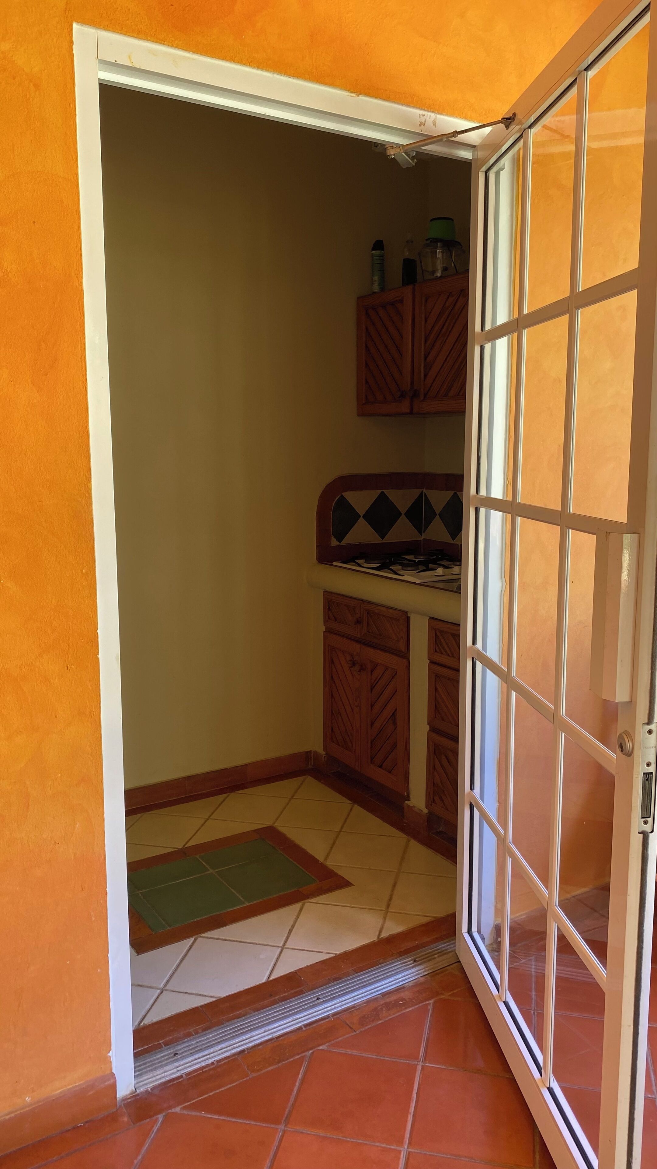 A kitchen with a tiled floor, wooden cabinets, and a gas stove.