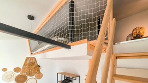 A loft-style room with a wooden ladder, a mesh enclosure, and a hanging light fixture. - 2 bedroom stunning home in L'Aiguillon la Presqu' (L'Aiguillon la Presqu')