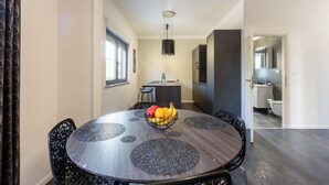 Un comedor moderno con una mesa redonda, sillas negras y un frutero.