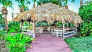 A thatched-roof pavilion with outdoor seating, surrounded by lush greenery. - Go!#12 - BAHAMA BAY - Three Bedroom Resort, Sleeps 6 (Davenport)