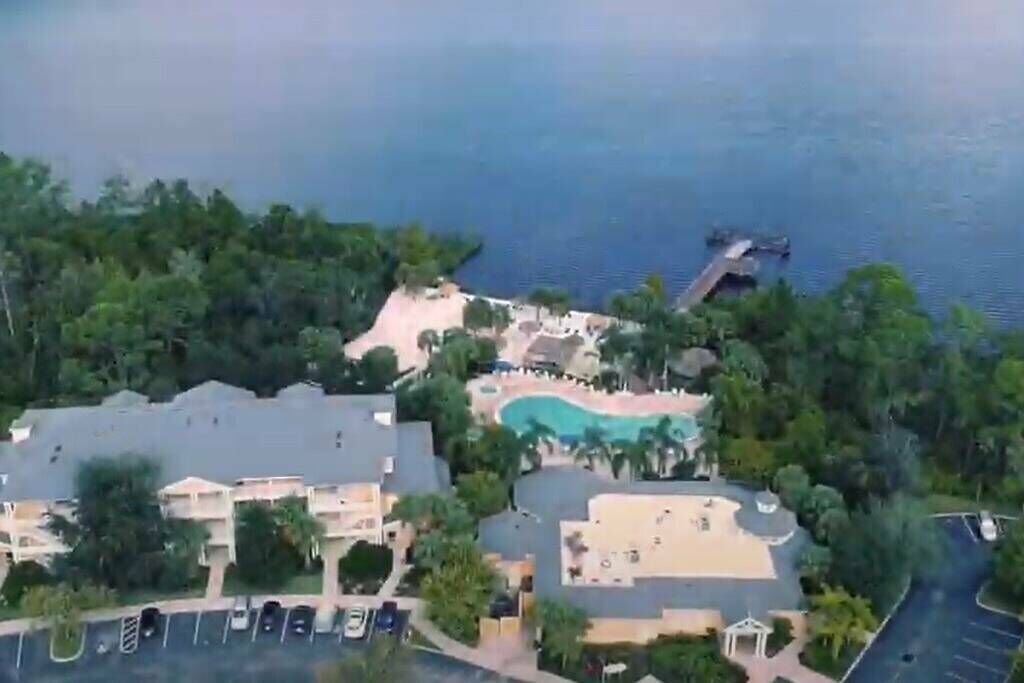 Un complexe hôtelier doté d’une piscine, d’un parking et de bâtiments entourés de verdure.