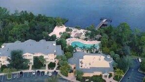 A resort with a swimming pool, parking area, and buildings surrounded by greenery. - Go!#12 - BAHAMA BAY - Three Bedroom Resort, Sleeps 6 (Davenport)