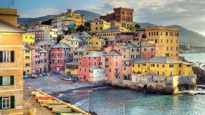Un pueblo costero con edificios coloridos, una playa y barcos.