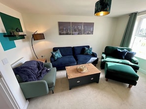 A living room with a sofa set, a coffee table, and a lamp.