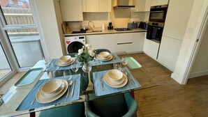 Una cocina moderna con comedor dispuesto para cuatro personas.