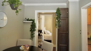 A dining area with a round table, chairs, a clock, and a hanging plant. - Luxurious 3-Level Home Minutes from Washington D.C. (Arlington)