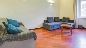 Un salon avec un canapé, une petite table et une fenêtre.