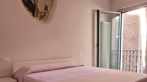 Une chambre à coucher avec un lit, une table de chevet, un miroir et un radiateur.