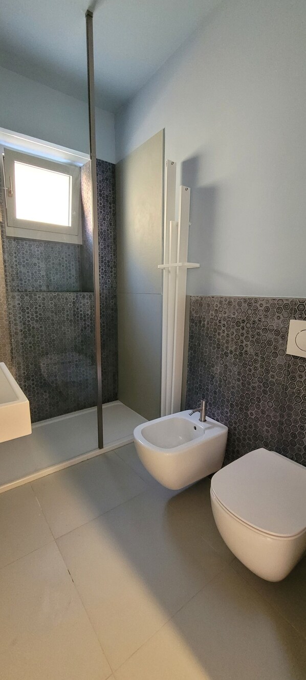 A modern bathroom with a bathtub, two sinks, and a shower.