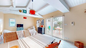Een ruime kamer met een bed, een televisie, een eettafel en uitzicht op het omliggende landschap.