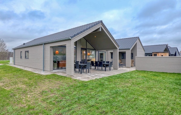 Une maison moderne dotée d’un patio couvert et d’un espace salon extérieur.