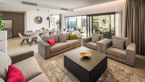 Un salon moderne comprenant un ensemble de canapés, une table basse et un coin repas avec des chaises et une table.