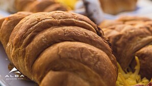 A plate of croissants with a blurred background featuring a sign that reads "ALBA". - Alba pyramids view inn (Giza)