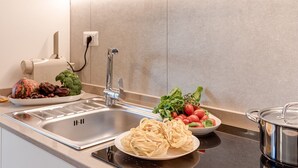 Une cuisine équipée d’un évier en acier inoxydable, d’une cuisinière et de divers aliments disposés sur le plan de travail.