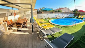 A poolside area with a covered seating area, a pool, and a lifebuoy on the wall. - Apart. with 4 suites, 10 people with saltwater pool and barbecue in the Algarve (Quarteira)