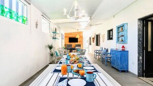 A dining area with a long table set for breakfast, featuring plates, cups, and a variety of food items. - Apart. with 4 suites, 10 people with saltwater pool and barbecue in the Algarve (Quarteira)