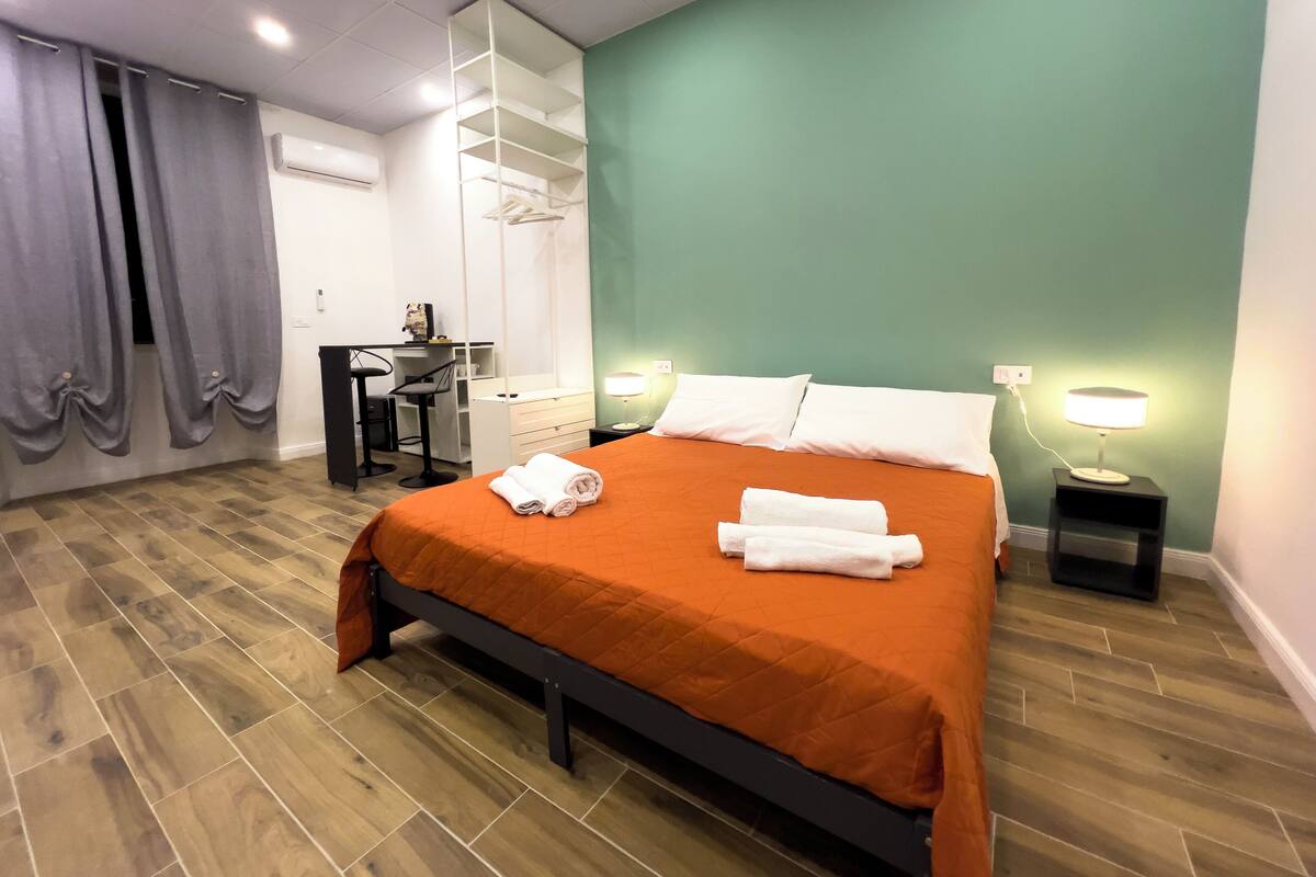 Une chambre d’hôtel comprenant un lit, un bureau, une chaise, une armoire et une salle de bain.