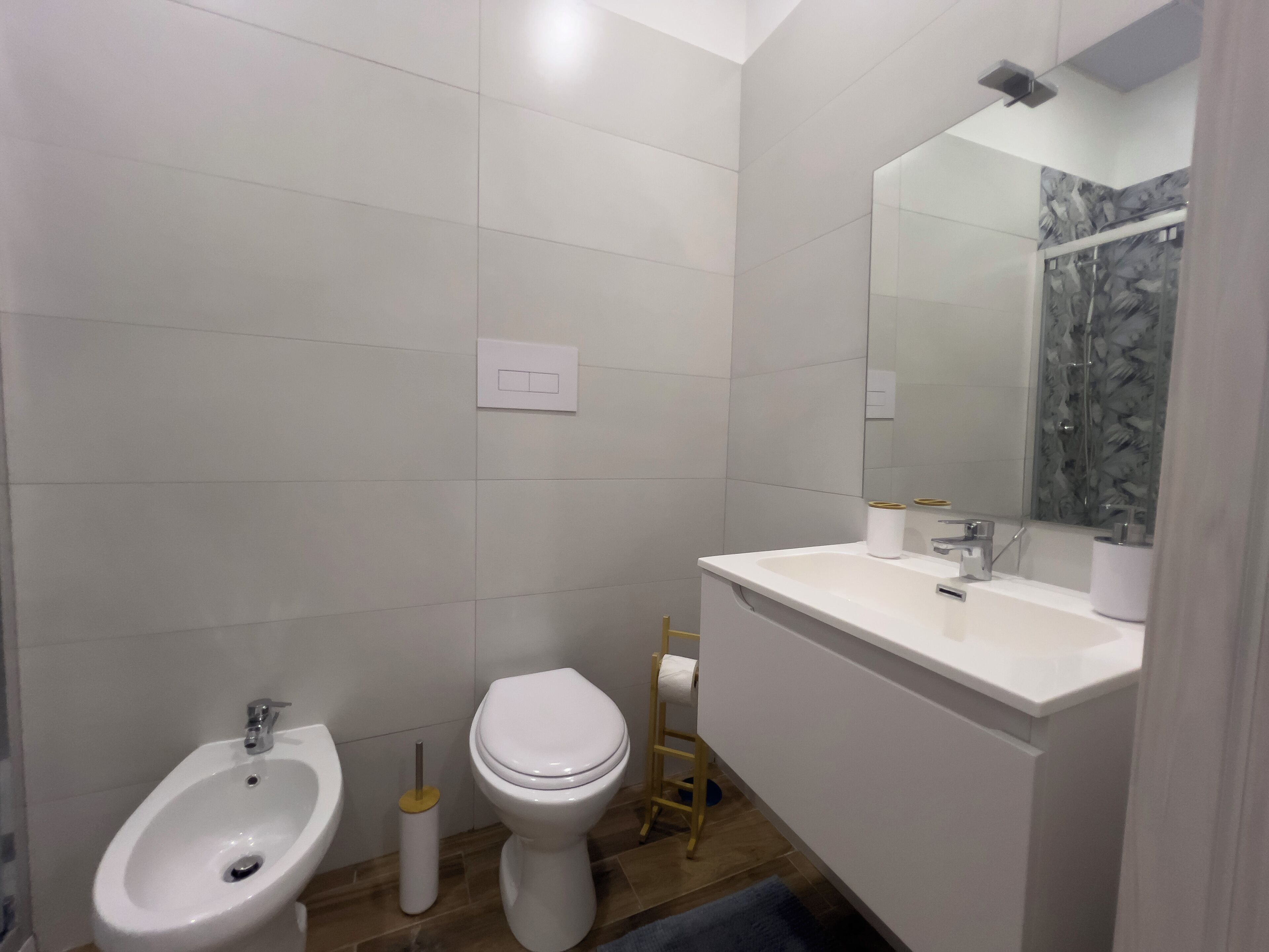 A modern bathroom with a bidet, toilet, and sink.