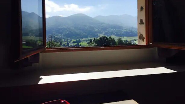 A room with a large window offering a view of a mountainous landscape. - Large, comfortable house in Bagneres  (Bagnères-de-Bigorre)
