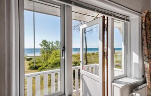 A room with a large window overlooking a beach and ocean. - Cozy home in Faxe Ladeplads with WiFi (Faxe Ladeplads)