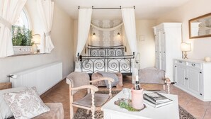 A cozy bedroom with a canopy bed, a white dresser, and a small sitting area with a table and chairs. - Nice apartment in Murzasichle with sauna (Murzasichle)