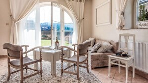 A cozy room with a large window, a sofa, two chairs, a small table, and a radiator. - Nice apartment in Murzasichle with sauna (Murzasichle)