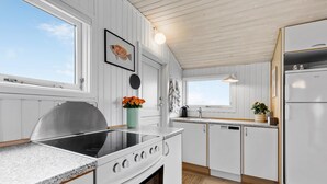 Une cuisine moderne avec des meubles blancs, une cuisinière en acier inoxydable et un réfrigérateur.