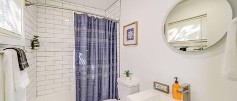 Une salle de bain avec douche, toilettes et lavabo.
