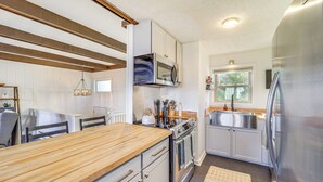 A modern kitchen with wooden countertops, stainless steel appliances, and a window providing natural light. - 1 Mi to Skiing: Cozy Townhome in Beech Mountain! (Banner Elk)