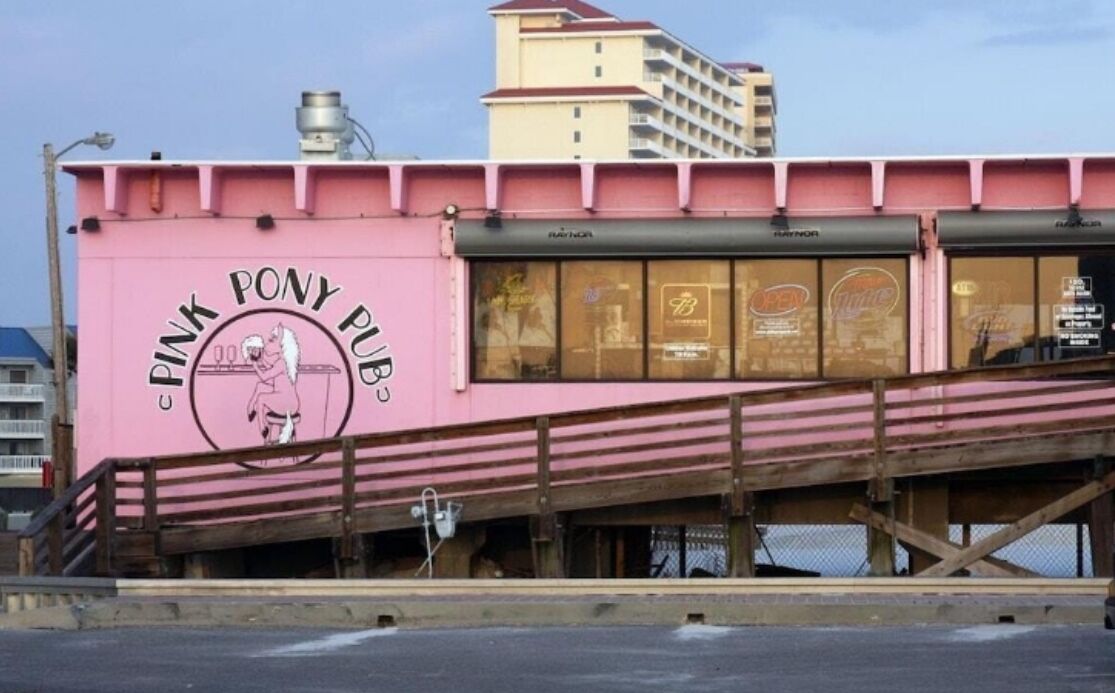 A pink building with a sign that reads "Pink Pony Pub."