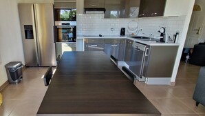 A modern kitchen with stainless steel appliances, a built-in oven, and a coffee maker. - Cosy room (Prévessin-Moëns)