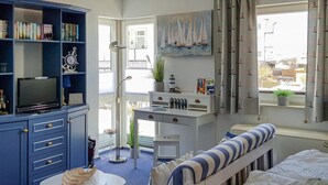 A child's bedroom with a bookshelf, a desk, a bed, and a window with curtains. - 1 bedroom awesome apartment in Sassnitz (Sassnitz)