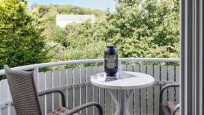 A balcony with wicker chairs, a small round table, and a decorative vase. - 1 bedroom awesome apartment in Sassnitz (Sassnitz)