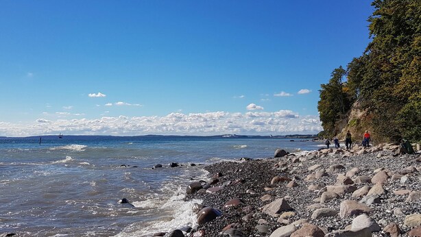 A rocky beach with clear blue water and a distant view of mountains. - 1 bedroom awesome apartment in Sassnitz (Sassnitz)