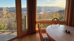Ein Zimmer mit großen Fenstern und Blick auf eine Berglandschaft und einen See.