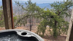 Ein Whirlpool mit Blick auf Wald und Berge.
