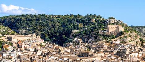 A densely packed urban area with historical buildings and a prominent hilltop structure.