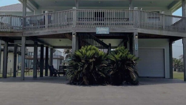 A two-story building with a covered patio area and a sign indicating it is a restaurant.