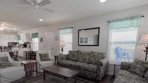 A living room with a sofa, chairs, a coffee table, and a dining area with a table and chairs.