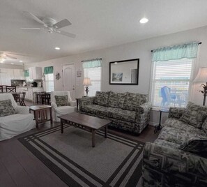 A living room with a sofa, chairs, a coffee table, and a dining area with a table and chairs.