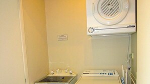 Ein Waschraum mit Trockner, Waschmaschine und Abluftventilator.