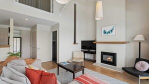 Una sala de estar moderna con chimenea, un sofá, una mesa de centro y un televisor.