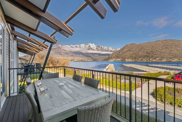 Un balcon avec vue sur les montagnes et un lac.