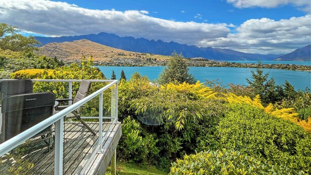 Une terrasse avec vue sur un lac et des montagnes.